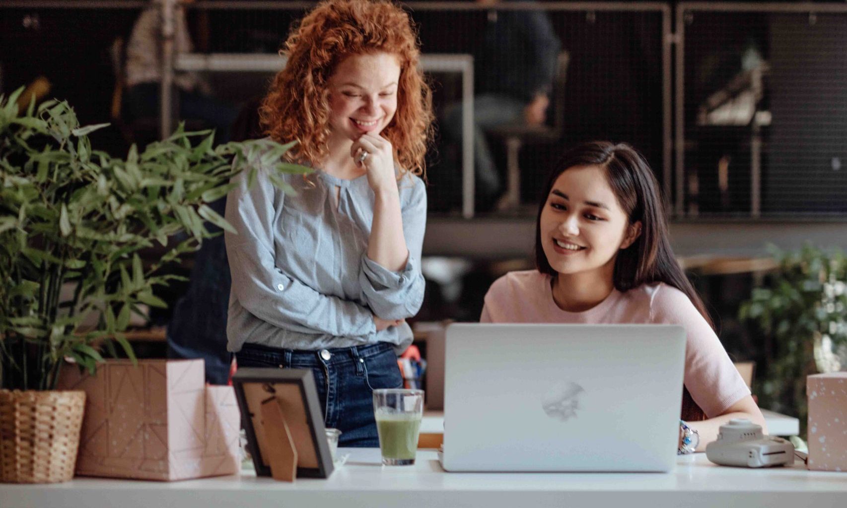 Two people overlooking a computer